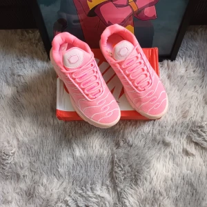 Nike Air Max rosa sneakers - Nike Air Max sneakers i en snygg ljusrosa färg med vita detaljer och vågiga mönster på ovandelen. Skorna har synlig Air Max-dämpning i sulan, mesh och syntetmaterial samt klassisk snörning. Perfekta för dig som vill sticka ut med en fräsch och sportig look.