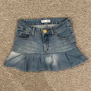 Jeanskjol med volang  - Säljer en blå jeanskjol från 157 med volang nertill och klassiska fickor fram och bak. Vet inte vad storleken är men skulle tro att det är en xs eller lite mindre.  Midjemåttet är ungefär 73 cm