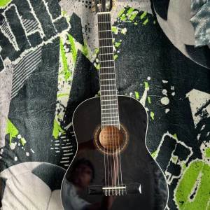 Cataluña SGN-C81-PO gitarr - Snygg klassisk gitarr i svart finish, perfekt för dig som vill börja spela eller ta ditt musicerande till nästa nivå. Lättspelad och stilren – ett grymt val för unga musiker och kreativa själar!