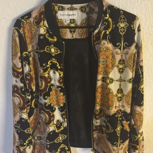 Mönstrad bomberjacka från KappAhl - Snygg bomberjacka från KappAhl med unikt mönster i svart, gult, orange och beige. Jackan har dragkedja framtill, ribbade muddar och coola detaljer. Perfekt för dig som vill sticka ut med en färgstark och trendig look.