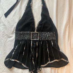 Vintage svart paljett halterneck - Svart halterneck med fina silvriga paljett detaljer! Säljer för den är för stor för mig💗 Tror att den  skulle vara någon med större byst💋Storlek <M/L!! Använd köp nu funktionen💗