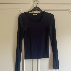 Mörkblå långärmad topp från Kappahl - Säljer en enkel tunn mörkblå långärmad tröja från Kappahl. Modellen är figurnära med rund halsringning och mjukt bomullsmaterial. Perfekt att ha till en kjol eller jeans. Använd fåtal gånger med inga defekter. Skriv för frågor, kan gå ner i pris💗
