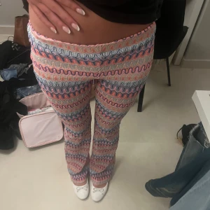 Mönstrade byxor från Hm - Färgglada byxor från hm med vågigt mönster i rosa, blått, vitt och rött. Byxorna har normal passform och är raka i modellen. Perfekta för dig som gillar unika plagg med mycket färg och mönster.