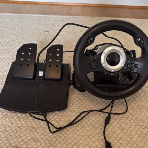 Ratt och pedaler till spelkonsol - Uppgradera din gamingupplevelse med denna ratt och pedalset! Perfekt för dig som älskar bilspel och vill känna dig som en riktig racerförare. Kompatibel med flera spelkonsoler och har realistisk känsla i både ratt och pedaler.