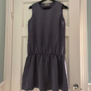 Lila ärmlös klänning från Hunkydory - Säljer en stilren lila ärmlös klänning från Hunkydory. Klänningen har en avslappnad passform med en elastisk midja som ger en fin siluett. Perfekt för varma dagar, sommarens fester men också under kallare dagar med en fin kofta till.