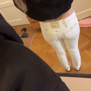Vita jeans från Levi's  - Säljer ett par unika vintage jeans från Levi’s i en cream/vit nyans. De har låg midja, raka ben och är gjorda i 100% bomull – både bekväma och stilrena.  Extra cool detalj: dragkedjor vid bensluten som du kan öppna om du vill ha en utsvängd look. Så snygga och mångsidiga!  Pris kan diskuteras, så passa på! Hör av dig om du vill ha fler bilder eller info.