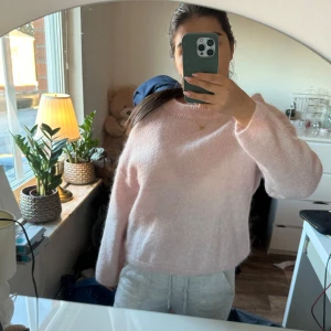 Ljusrosa stickad tröja - Mysig ljusrosa stickad tröja med rund hals och långa ärmar. Perfekt för kyliga dagar när du vill hålla dig varm och bekväm. Tröjan har en enkel och stilren design som passar till det mesta. Ett måste i garderoben för den som älskar mjuka och sköna plagg.