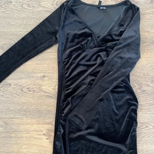 Svart klänning från H&M  - Säljer nu min svarta enkla klänning från H&M. Aldrig använd och ska va glitter men tvättad så glittret finns inte kvar. Är en lite ”sammet” känsla på tyget. Sitter bekvämt, storlek M. Säljer för 80kr💗