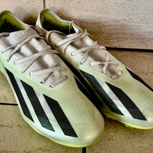 Vita fotbollsskor från Adidas - Säljer ett par fotbollsskor från Adidas Modelll: X Crazyfast 2 MG/Q3 för  gräs/ konstgräs. Storlek: 40 Inköpta hösten 2024 Nypris: 840:-