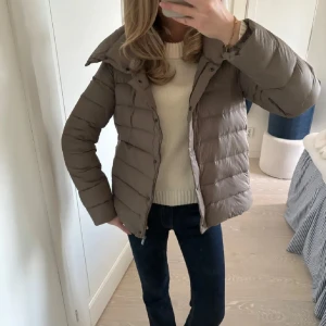 Dunjacka - Säljer en snygg dunjacka med dragkedja och knappar. Jackan har en hög krage och långa ärmar. Säljer då jag inte använder den längre