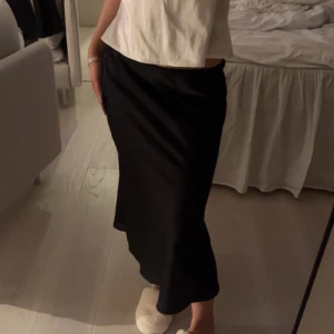 Svart långkjol - Snygg svart långkjol i satin.