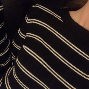 Svart och vit randig tröja - Säljer en svart tröja med vita ränder. Tröjan har en tight passform och långa ärmar, perfekt för en stilren look. Den är enkel att matcha med olika outfits.