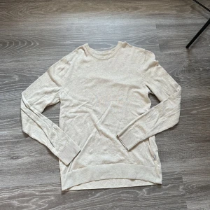 Beige tröja från Jack & Jones - Säljer en stilren beige tröja från Jack & Jones storlek S. Tröjan har långa ärmar och ribbade muddar vid ärmslut och nederkant. Perfekt för en avslappnad och snygg look.