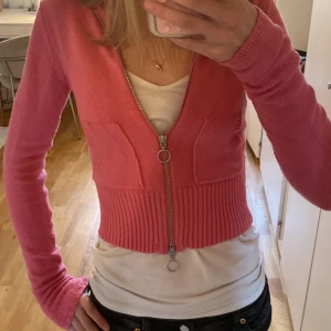 Rosa kofta från Nelly - Säljer en söt rosa kofta från Nelly med dragkedja framtill. Koftan har långa ärmar och ribbade detaljer vid ärmslut och nederkant. 💕