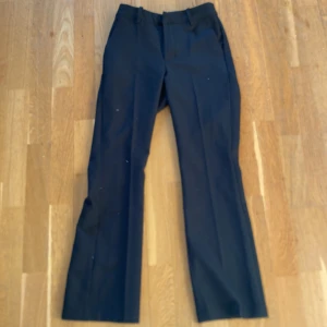Svarta kostymbyxor från BikBok - Snygga svarta kostymbyxor från BikBok med en klassisk rak passform. Perfekta för en stilren look. Byxorna har en midwaist design och är tillverkade i ett bekvämt material.