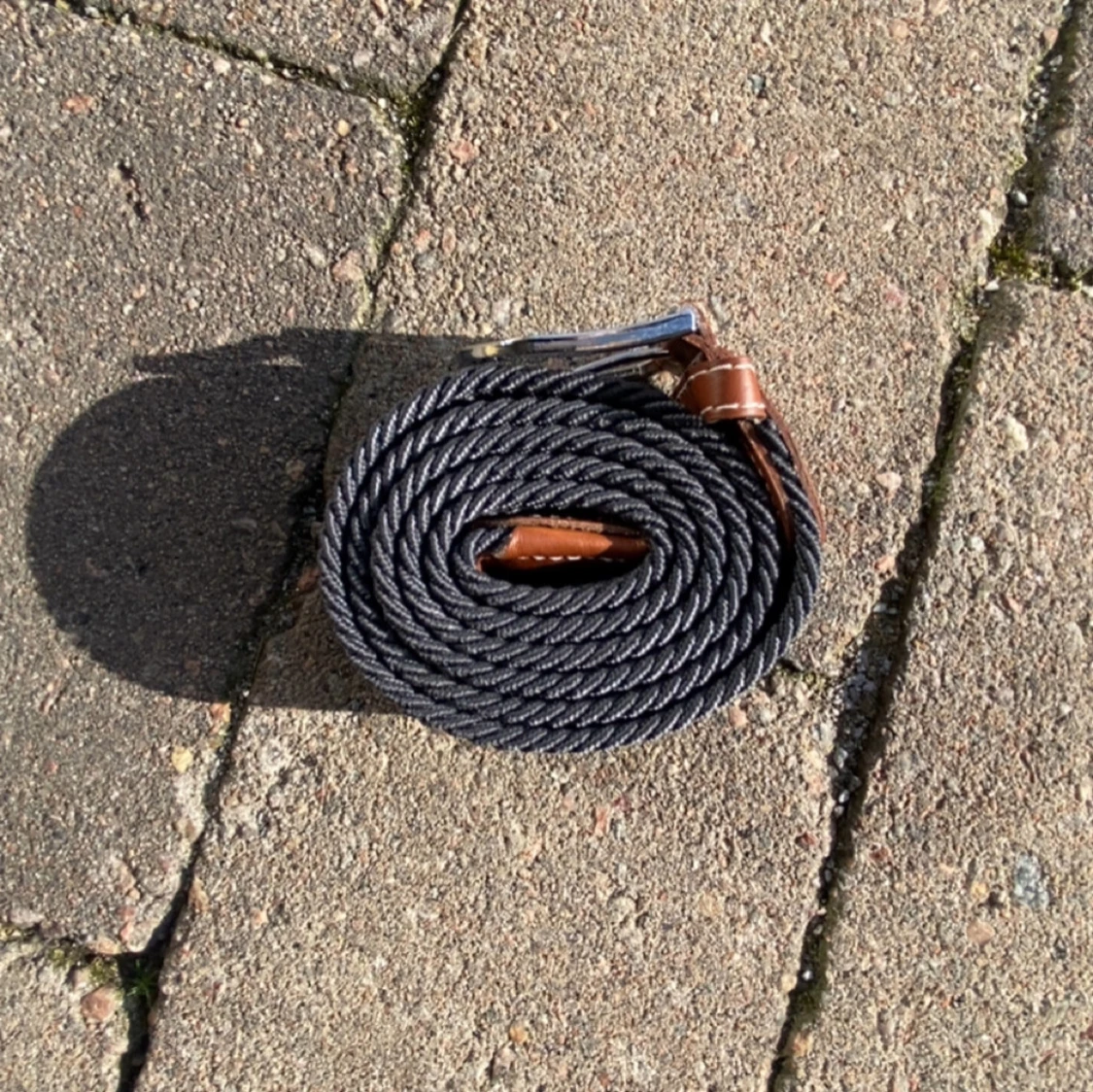 Svart flätat bälte med bruna detaljer