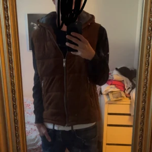 (Stenström liknande väst) - Snygg brun mocka väst med dragkedja och huva. Perfekt skick och inte använd mycket. Västen är i mocka och är väldigt fin. Stolek S men passa dig från 170-180 rätt bra. Skriv vid minsta fundering! 