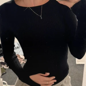 Svart ribbad långärmad tröja från BikBok - Säljer en svart, tight och ribbad långärmad tröja från BikBok. Tröjan har en rund halsringning och är tillverkad i ett stretchigt material som sitter snyggt på kroppen. Perfekt baströja till garderoben!