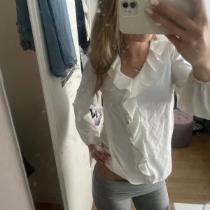 Vit Blus - Jätte fin volang blus. Den är i bra skick men har dock nån liten fläck här och var som jag sett, så var beredda på att det kan finnas någon fläck. Det är inget man tänker på. Storlek xs/s