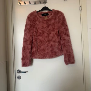 Rosa pälsjacka från Bik Bok - Säljer en fluffig och mjuk rosa fuskpälsjacka från vero Moda. Jackan har rund halsringning, långa ärmar och är helt täckt i fuskpäls. Perfekt för att ge outfiten en trendig touch. Storlek XS men kan vara något rymlig i storlek. Mycket fint skick, inga synliga anmärkningar eller defekter. 