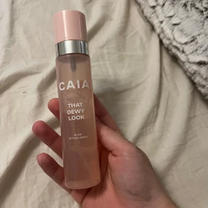 CAIA That Dewy Look Glow Setting Spray - Glow Setting Spray från CAIA i en snygg rosa flaska med silverdetalj. Ger en fräsch, daggig finish och hjälper sminket att hålla längre. Perfekt för dig som vill ha extra lyster i din makeup-rutin. Innehåller 100 ml. Men kanske runt 80ml kvar 