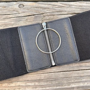 Snyggt brett elastiskt midjebälte! - Snyggt brett elastiskt midjebälte med dragkedja och stor ring i metall fram. B: 12 cm. L: 60 cm (+25). Oanvänt.
