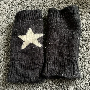 Hand värmare med stjärn mönster - Stickade fingerlösa vantar i svart och vitt med ett tydligt stjärnmönster på ovansidan.⭐️ Ena sidan är helsvart med vit stjärna, andra sidan är vit med svart stjärna💕🍂☺️. Perfekta för dig som vill ha värme men ändå kunna använda mobilen.❤️ Den är lite nopprig men det kan tas bort!💕