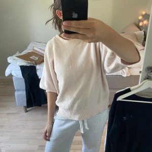 Ljusrosa stickad tröja - Mysig ljusrosa stickad tröja med rund halsringning och trekvartsärmar. Tröjan har en avslappnad passform och breda muddar vid ärmslut och nederkant. Perfekt för lager-på-lager och enkel att styla till olika outfits.