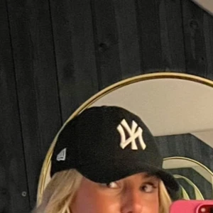Svart New York Yankees keps - Säljer en svart keps från New Era med New York Yankees-logga broderad i vitt framtill. Klassisk böjd skärm och justerbar passform. Perfekt accessoar för en sportig och avslappnad stil. Den har bra färg och är inte använd mycket. Dock har den sminkfläck på insidan vid pannan.