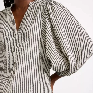 Randig blus med puffärm från Lindex  - Säljer en snygg randig blus från lindex med svarta och vita ränder. Blusen har v-ringning, knappar framtill och stora puffärmar som ger en trendig look. Perfekt att styla med jeans eller kjol. Den är aldrig använd 