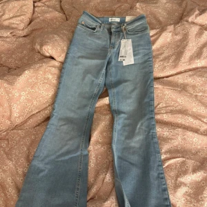 Ljusblå bootcut jeans - Säljer ett par ljusblå jeans med bootcut-modell och klassiska fem fickor. Byxorna har låg midja och stängs med dragkedja och knapp. Perfekta för dig som gillar en retroinspirerad look.💞💞