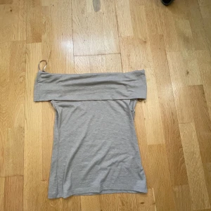 Beige offshoulder topp från Kappahl - Säljer en beige offshoulder topp från Kappahl i mjuk bomullsmix. Toppen har en bred kant upptill som vilar över axlarna och en tight passform. Aldrig använd💗