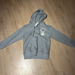Ami paris hoodie - Hej! Säljer nu en stilren grå ami Paris hoodie med vitt hjärta. Storleken på tröjan är S men passar även M. Hör av er vid frågor.