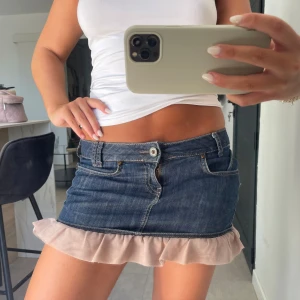 Jeanskjol med volangkant - Såå fin jeanskjol med ljusrosa volang längst ner. Stretchigt material så super bekväm! Skriv för fler bilder. Lite sliten på ”lappen” i bak men det är inget man tänker på, se sista bild 