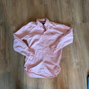 Rosa Ralph Lauren skjorta - Säljer denna rosa Ralph Lauren skjorta då den inte används. 	•	Storlek: S 	•	Passform: Regular fit 	•	Material: 100% bomull 	•	Fint skick, endast sparsamt använd 	•	Perfekt både till vardag och mer uppklätt  