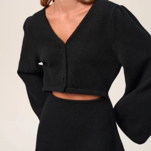 Adoore svart stickad klänning - Så himla fin stickad klänning från Adoore med vida armar och en ”slits” vit midjan. Även knappe upptill. Helt ny med prislapp kvar! Storlek 34 men skulle säga att den även passar större storlekar då den är stretchig i matrialet. 