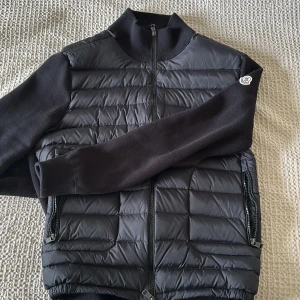 Svart Moncler cardigane  - Snygg svart cardigane från Moncler med stickade ärmar och quiltad kropp. Skulle säga om du är 185 eller kortare så sitter den här perfekt på dig tveka inte att skriva om du har några frågor. 😊helt ny använd 3 gånger typ 