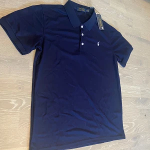 Marinblå Polo Ralph Lauren t-shirt - •Säljer en jätte stilig Marinblå Ralph Lauren Piké.  •Den är inte använd bara testad, jätte bra skick och inga fläckar eller hål.  •Och det är storlek M och måtten finns på dem sista bilderna •Priset kan diskuteras och skickar inom 24 Tim 💨😊