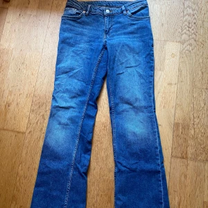 Blå bootcut jeans från Monki - Säljer ett par klassiska blå jeans från Monki med bootcut-snitt. Jeansen har fyra fickor, normal passform och är tillverkade i jeansmaterial. Perfekta för dig som gillar en tidlös look med lite utsvängda ben. Skulle kunna passa en person som har xs också.