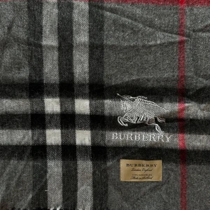 Burberry- ikoniska gråa halsduk  - Snygg halsduk från Burberry i klassiskt rutigt mönster med grå, svart, vit och röd färg. Broderad Burberry-logga med riddare och etikett som visar att den är gjord av 100% kashmir. Perfekt accessoar för att lyfta din stil. Helt oanvänd och ny- helt perfekt för vinter! Det är den längre versionen så man kan stylea den på flera olika sätt