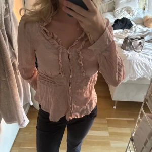 Ljusrosa blus med volangdetaljer - Supersöt ljusrosa blus med volanger. Använt typ en gång