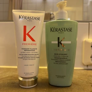 Kérastase hårvård duo - Två hårvårdsprodukter från Kérastase: en vit tub med röd logga, Fondant Fluidité Réparateur med citronsyra och glycin, samt en grön pumpflaska, Bain Divalent med aminosyra och vitamin B6. Perfekt för dig som vill ge håret extra vård och balans.