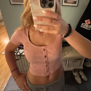 Rosa ribbad croppad topp med knappar - Superfin ljusrosa croppad topp med ribbad struktur och snygga knappar. Köpte för ett tag sen men har nästan aldrig använts. 💞💞