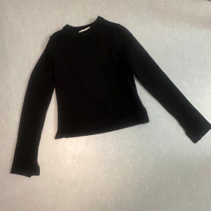 Svart stickad tröja från Zara - En svart stickad tröja från Zara med långärmad modell och rund hals. Tröjan har en enkel och stilren design med ribbad nederkant och ärmslut. Perfekt att matcha med jeans eller kjol för en snygg look. Skriv gärna för mer frågor och prissänkning💕