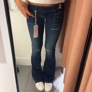 marinblå low waist bootcut jeans - Super snygga low waist bootcut jeans med slitningar, inte helt säker på o sälja men lite intresse koll, slutsålda i den storleken på hemsidan! Använda 1 gång💞 Storlek:XS