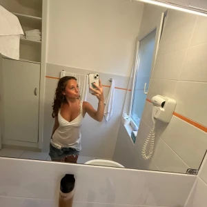 Vit mesh linnetopp från Nelly - Säljer en vit mesh linnetopp från Nelly med smala axelband och v-ringad omlott framtill. Toppen är lätt transparent och har en flowy, asymmetrisk nederkant som ger en trendig vibe. Perfekt att styla med jeans eller kjol för en cool look.