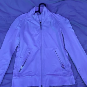 vit tröja från Casall - perfekt tröja med dragkedja till höst och vår! tröjan har ett bra skick och märket Casall under höger ficka, väldigt fin. 