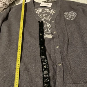 Grå kofta från Chrome Hearts  - Säljer en grå cardigan från Chrome Hearts i storlek XL men passar mer som L, längden är cirka 72cm och bröst cirka 57 cm. Använd bara en gång så den är i jätte bra skick 🏷️tagsen sitter kvar.  broderade logga bak. Stickad i mjukt material. 