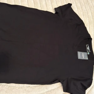 Svart och vit t-shirt från dressman - Två klassiska t-shirts från Dressman i svart och vitt. Båda har rund hals och korta ärmar, tillverkade i mjuk bomull som känns skön mot huden. Perfekt basic-plagg med normal passform och stilren look. Snygga att matcha med jeans eller shorts. Svarta tagg kvar, vita använd 1 gånc