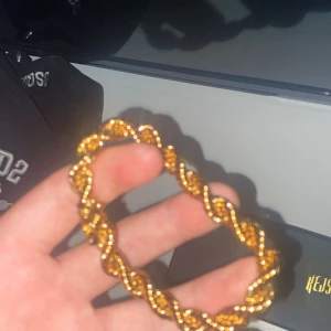 Guldigt  armband från Kejsar - Säljer ett snyggt armband från Kejsar i guldig färg. Armbandet har en tvinnad design som ger en lyxig känsla och är perfekt för att lyfta din stil. Låset är robust och smycket kommer i originalförpackning, Storlek 19,5 